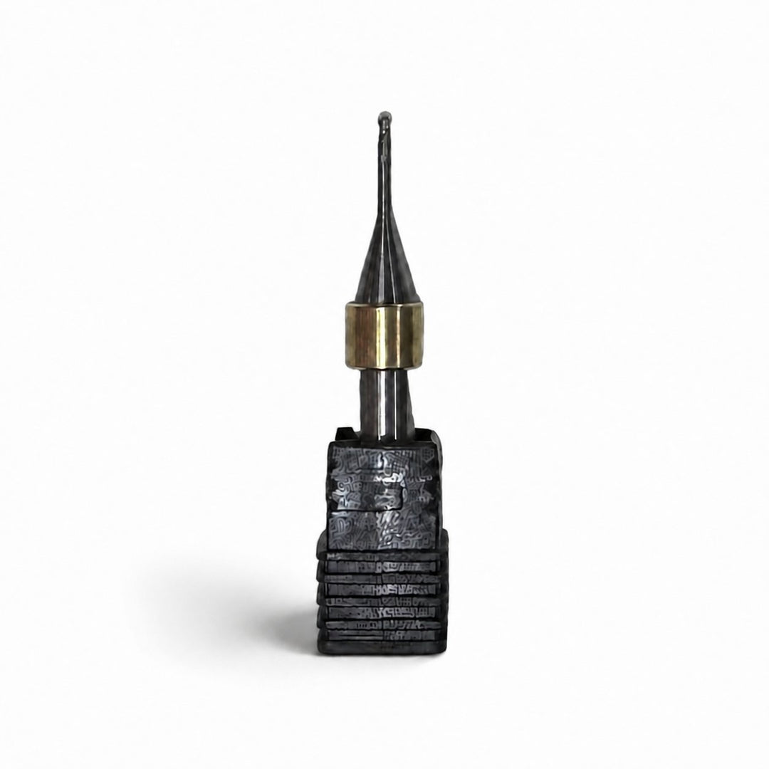 Aidite AMM-580 metal milling bur with black cutting head, brass collar, and silver shank on a white background.